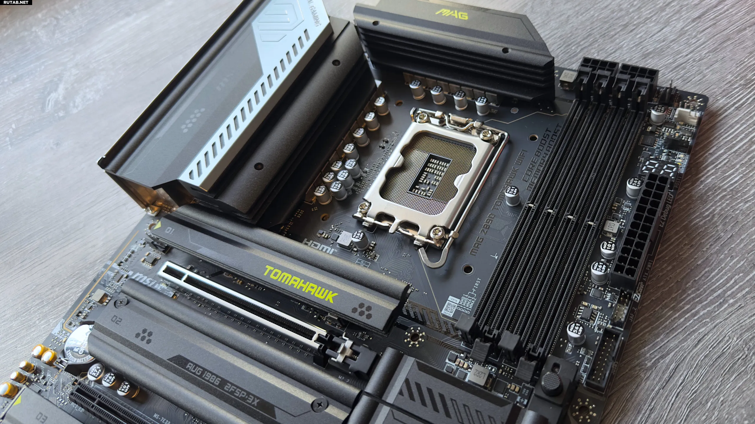 Фотография материнской платы MSI MAG Z890 Tomahawk WiFi, фокус на разъёмах процессора и оперативной памяти.