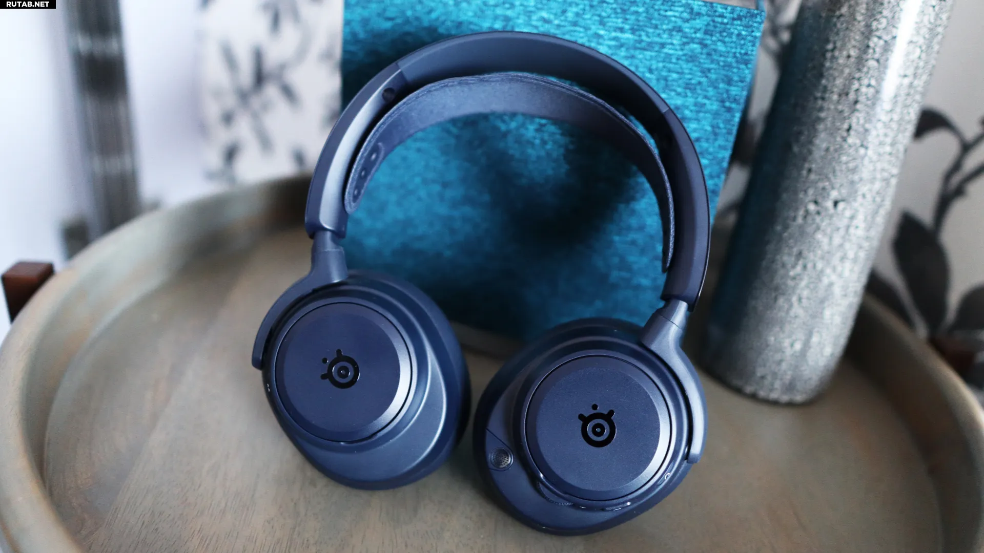 SteelSeries Arctis Nova Pro Omni на столе и стуле с аксессуарами.